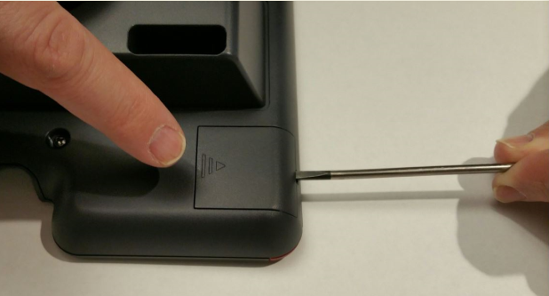 Insert screwdriver in the module panel opening